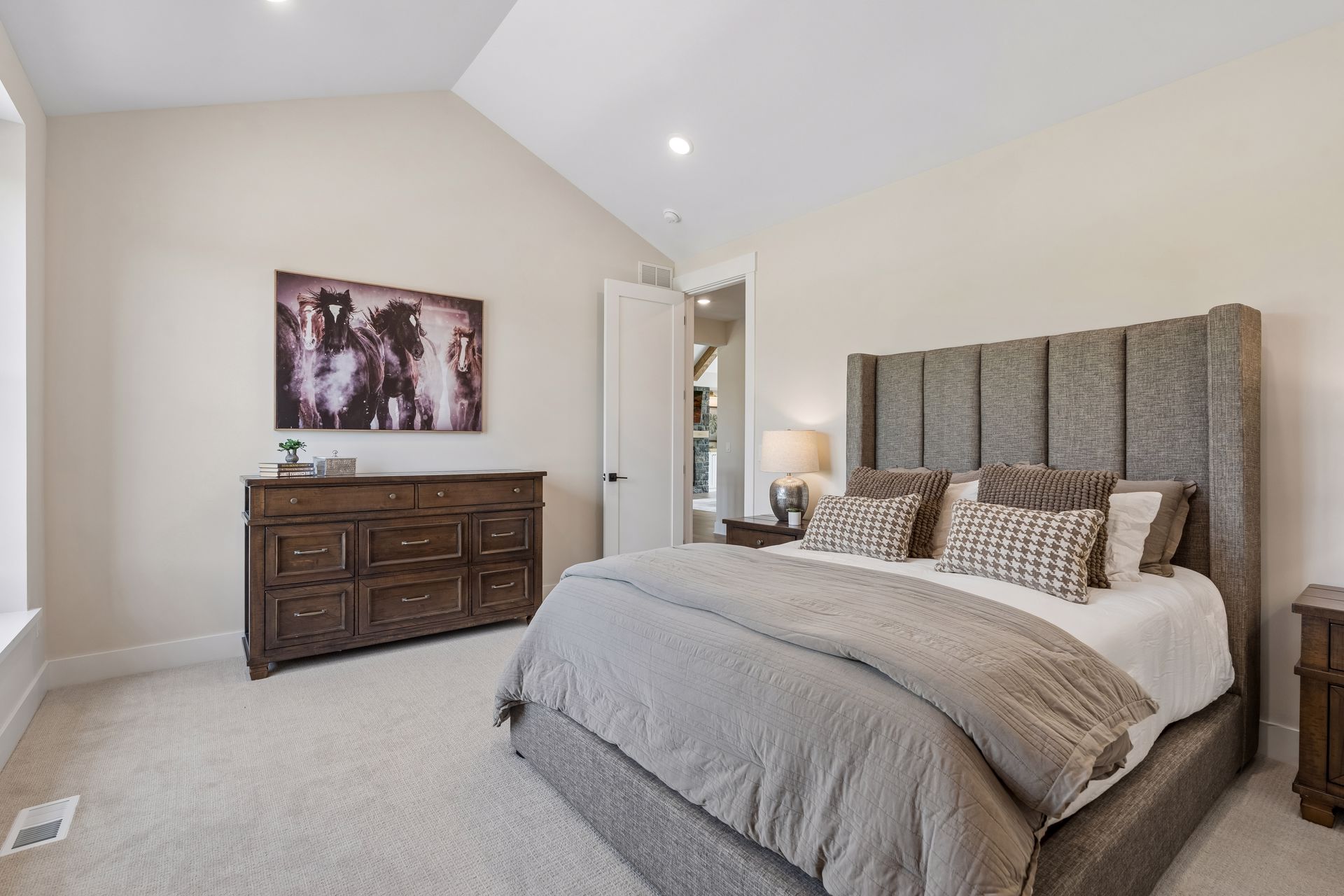 Guest bedroom with upholstered bed, accent wall and spacious layout